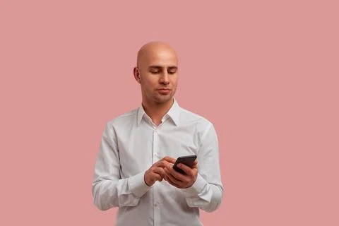 Technologies here. Calm serious bald man with bristle searching for informati Stock-Fotos