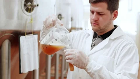 A technologist at a brewery pours beer into a test tube Stock Footage 158264823