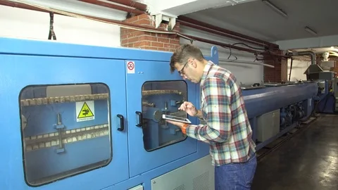 Technologist controls the work of the conveyor for the production of plastic Stock Footage 77826768