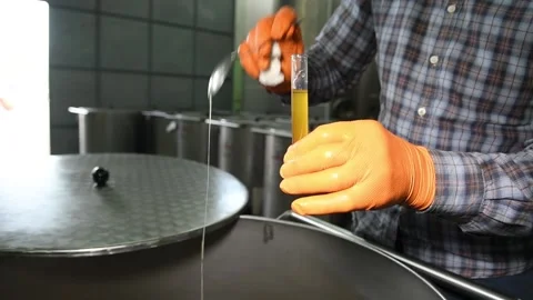 The technologist pours olive oil into a test tube to measure the degree of acid Stock Footage 140218649