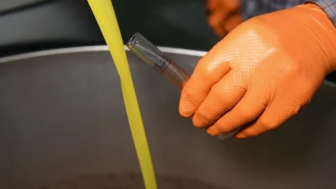The technologist pours olive oil into a test tube to measure the degree of acid Stock Footage 140218847