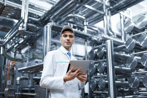 Technologist with a tablet in his hands at the dairy plant 写真素材