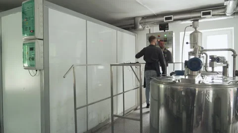 The technologist works by approaching the control panel of the cheese production Vidéo 177586283