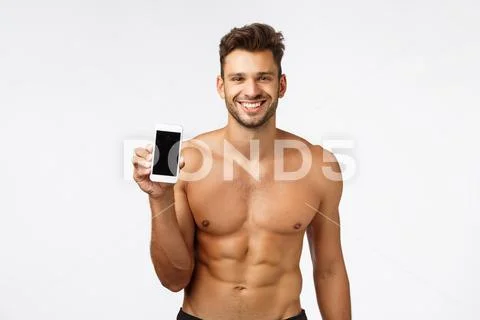 Technology, advertise and fitness concept. Sexy smiling strong, masculine Stock Photos