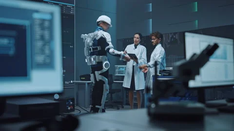 Technology and Development Laboratory Engineers Testing Exoskelet on Man Stock Footage 136595334