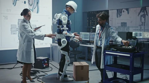 Technology and Development Laboratory Engineers Testing Exoskelet on Person Stock Footage 136595427