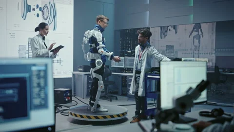 Technology and Development Laboratory Engineers Testing Exoskelet on Person Stock Footage 136595526