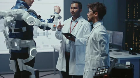 Technology and Development Laboratory Engineers Testing Exoskelet on Person Stock Footage 136595568