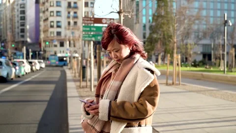 Technology and Mobility, Young Chinese Woman Calling for a Transportation S.. Stock Footage 272352104