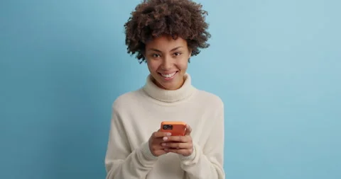 Technology and online communication concept. Pleased dark skinned woman with Stock Footage 143627702