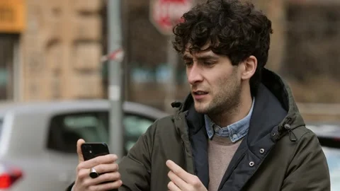 Technology, app - young man on video call with friend discusses with him  스톡 동영상 225475984