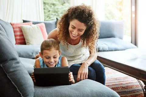 Technology both entertains and educates. a mother and her little daughter using Stock Photos