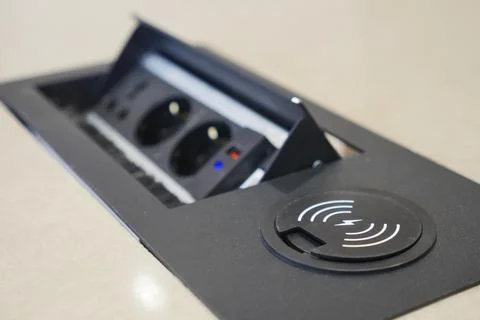 Technology for charging and plugging in devices at table Stock Photos