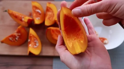 Technology of cleaning pumpkin from seeds with spoon, cooking in the kitchen. Stock Footage 164065166