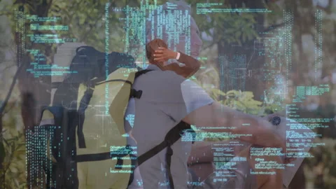 Technology code fading revealing sunlit forest while hiker pausing and companion Stock Footage 311141463