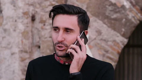 Technology, communication - young confident man talks on his smartphone - outdoo Stock Footage 142972990