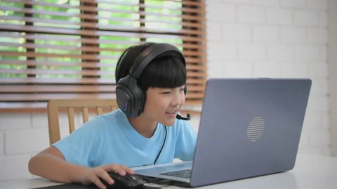 Technology concept of 4k Resolution. Asian boy playing computer games in the  Stock Footage 165943959