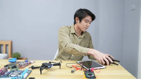 Technology concept of 4k Resolution. Asian man fixing drone in room. check fo Stock Footage 195373142