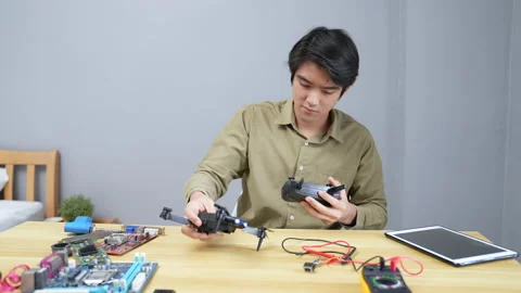 Technology concept of 4k Resolution. Asian man fixing drone in room. check fo Stock Footage 202050455