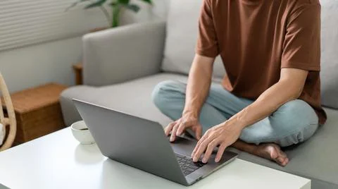 Technology Concept The man in brown T-shirt concentrating on typing something Stock Photos