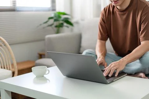 Technology Concept The man in brown T-shirt concentrating on typing something Stock Photos