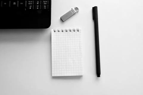 Technology concept of notepad and pen, laptop and flash drive Stock Photos