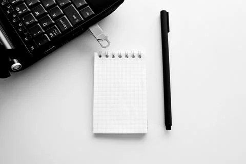 Technology concept of notepad and pen, laptop and flash drive Stock Photos