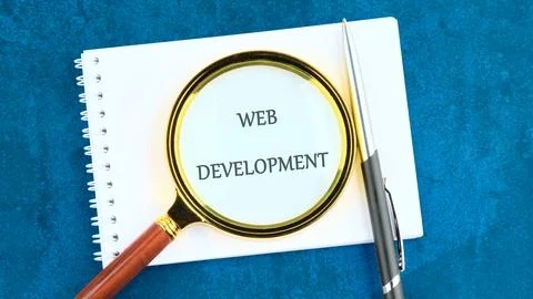 Technology concept. Words WEB DEVELOPMENT in a clean notebook through a mag.. Stock Photos