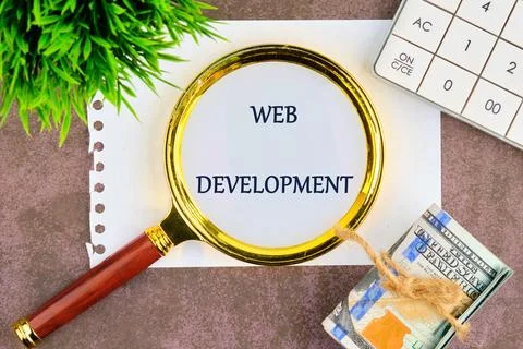 Technology concept. Words WEB DEVELOPMENT through a magnifying glass on a whi Stock-Fotos
