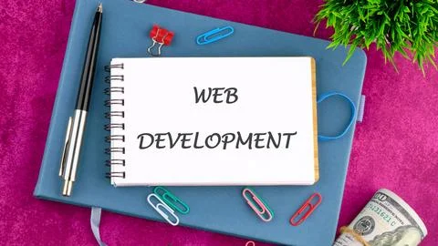 Technology concept. Words WEB DEVELOPMENT in a mini notebook on a business bo Stock Photos