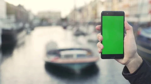 Technology concept: young man holding his smartphone with greenscreen chromakey Stock Footage 134384351