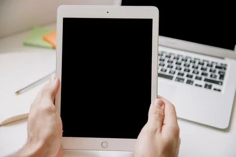 Technology desk concept with hands holding tablet. High quality and resolut.. Stock Photos