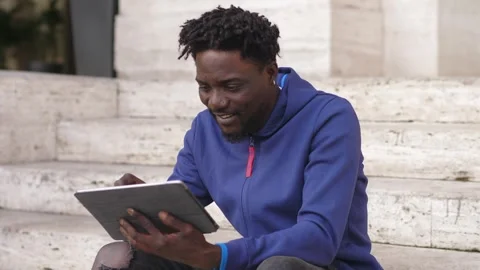 Technology, device-young black man smiles laughs while typing on tablet keyboard Stock Footage 240316332