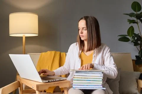 Technology in education. Wireless internet browsing. Serious young woman stud Stock Photos
