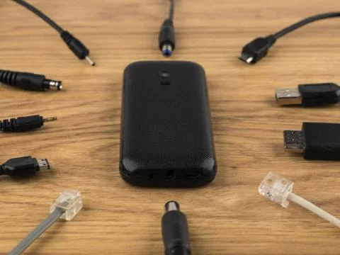 Technology generation gap: old dusty mobile phone cover up and lots of plugs  Stock Photos