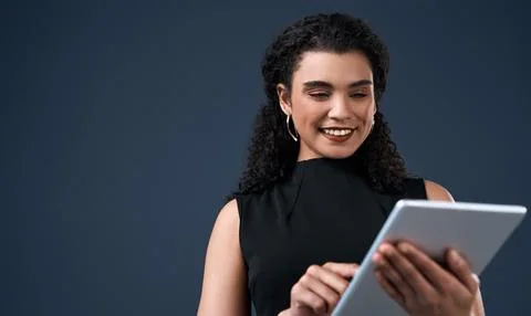Technology helps us evolve. an attractive young businesswoman standing alone and Stock Photos