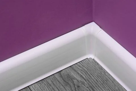 Technology of installation of a white floor plinth. home improvement concept Фото