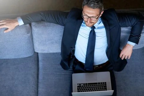 Technology keeps him at the top of his business game. a businessman using a Stock Photos