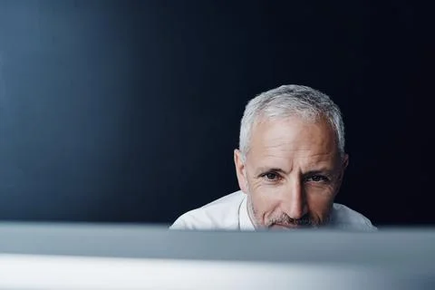 Technology, man working on his computer and against a studio background Stock Photos