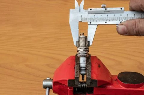 The technology of measuring the diameter of the spark plugs using calipers Stock Photos