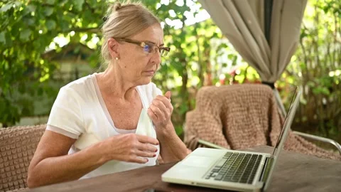 Technology, old age people concept - elderly senior woman takes off protective Stock Footage 141576433
