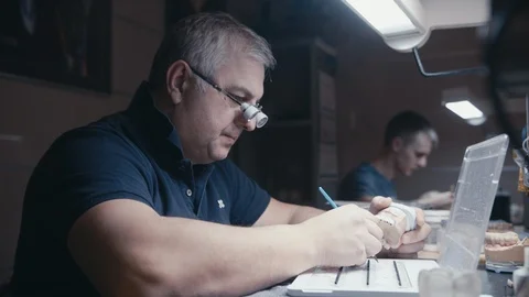 Technology production of dental implants, professional draws white paint on Stock Footage 102784161