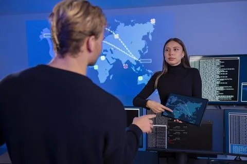 Technology professionals collaboratively analyzing real-time data in a cyber Fotos de archivo