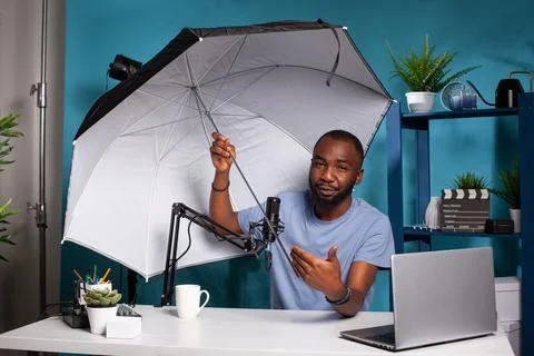 Technology reviewer testing flash reflector umbrella presenting size and Stock Photos