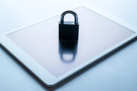 Technology security. Modern space grey mobile phone with padlock, key on whit Foto stock