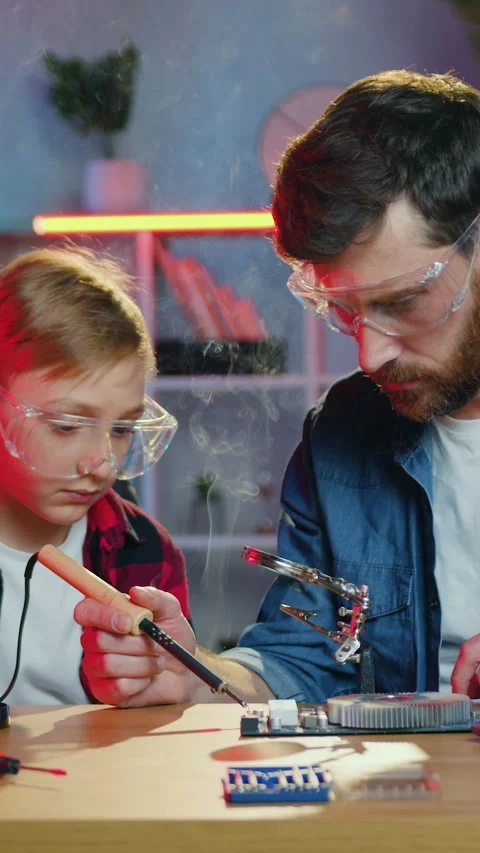 Technology soldering concept where attractive in good mood skilled bearded dad Stock Footage 329709886