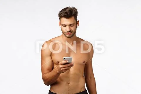 Technology, workout and fitness concept. Handsome shirtless strong sportsman put Stock Photos