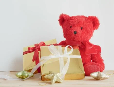 Teddy bear and gift boxes with stars on the wooden board Stock Photos