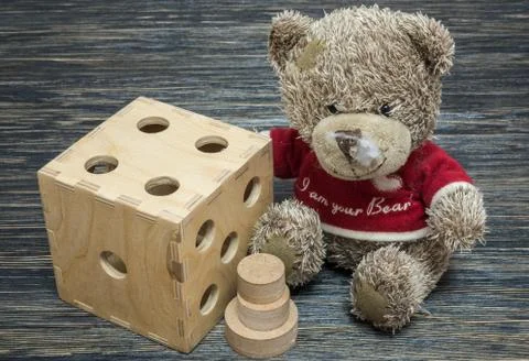 Teddy bear, big dice on old wood table Stock Photos