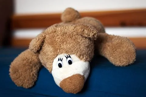 Teddy bear on the blue bed Stock Photos
